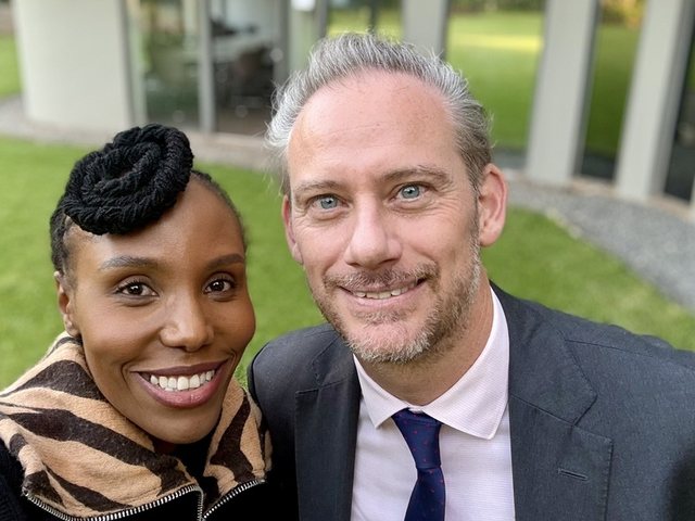 Olivia Otieno taking a selfie with a colleague on a lawn outside an office building