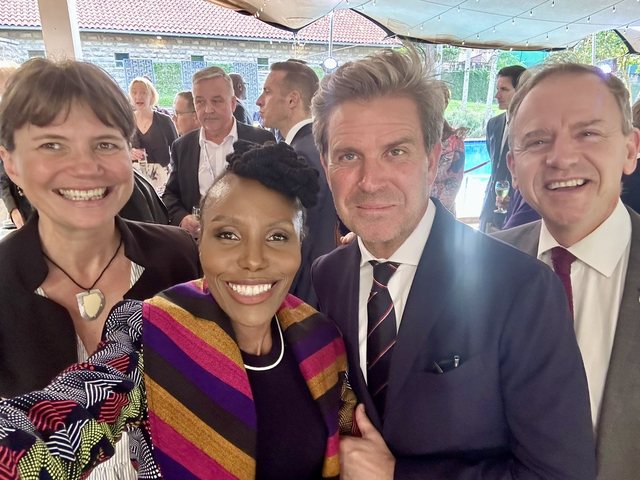 Olivia Otieno taking a group selfie with guests at an outdoor reception