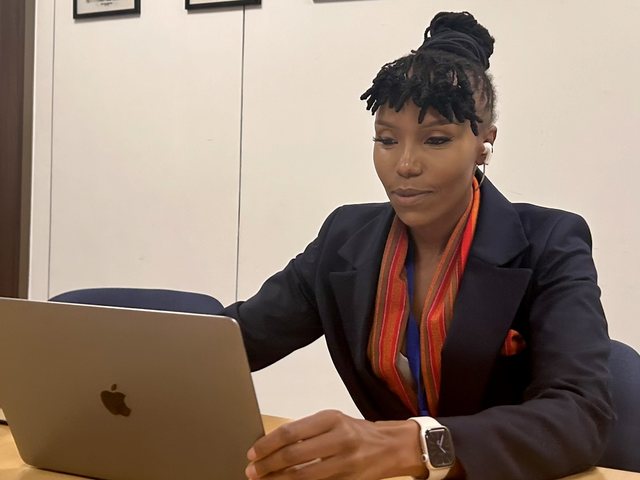 Olivia Otieno working on a laptop in a meeting room