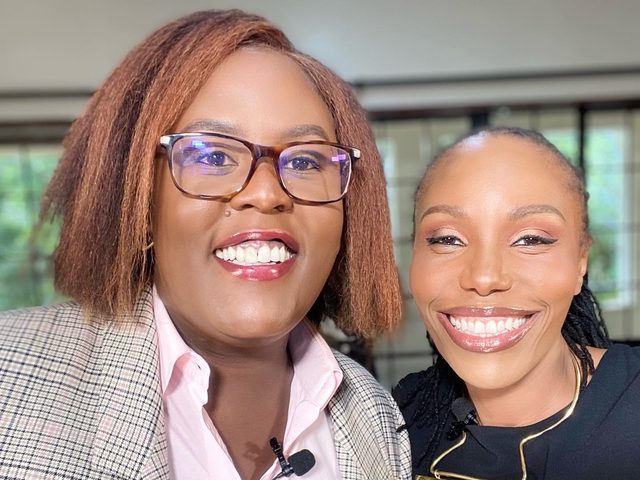Olivia Otieno taking a selfie with a colleague in a pink shirt and checked blazer