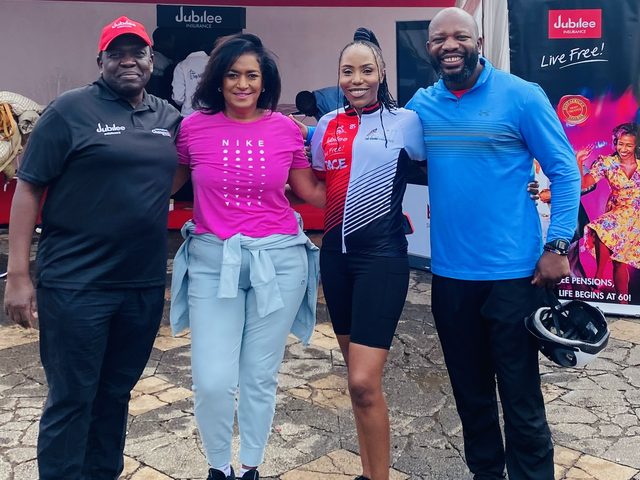 Olivia Otieno in a cycling jersey with three guests at the Jubilee Live Free Race