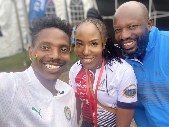 Olivia Otieno in a Jubilee Live Free Race jersey taking a selfie with two guests