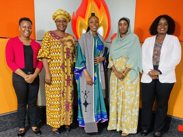 Olivia Otieno with four women guests in front of the Spice FM logo in the studio