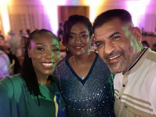 Olivia Otieno taking a selfie with two guests at an evening reception
