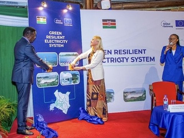 Olivia Otieno in a blue suit holding a microphone at the launch of the Green Resilient Electricity System